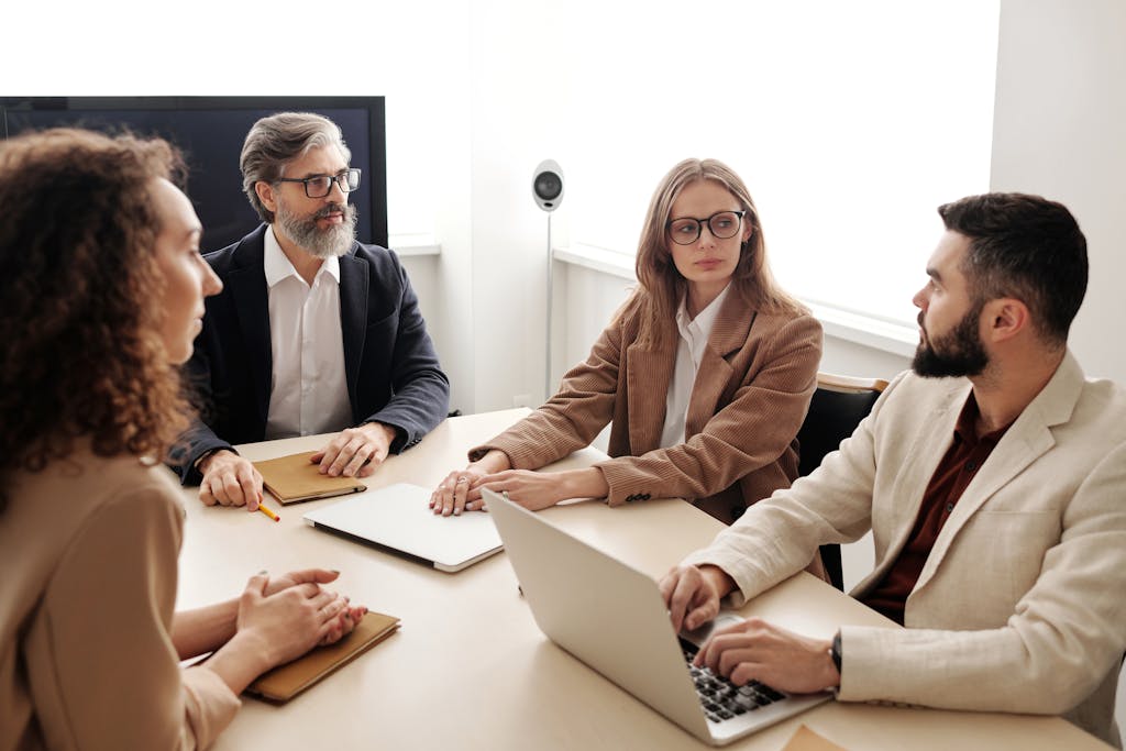 Business colleagues engaged in a serious discussion around a conference table.