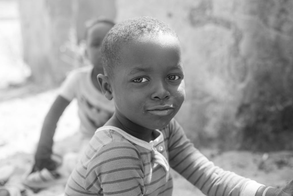 Joyful image of a child with short hair smiling, captured outdoors in Kaduna, Nigeria.